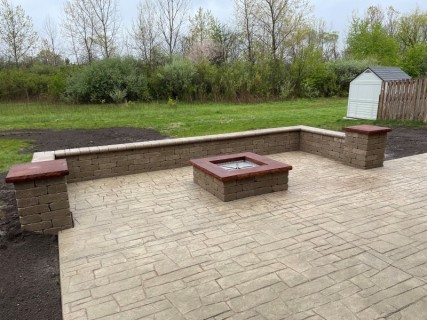 Dublin Cobblestone stamped concrete with Harvest Wheat integral, Colina Tan release and sand block fire pit and wall with leather top cap – Indy Decorative Concrete