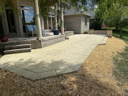 Appalachian Flagstone stamped concrete with Bone hardener, Arena Buff release, tooled and scored border, seat wall and columns with custom caps in Shelbyville Indiana – Indy Decorative Concrete