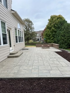 Majestic Ashlar Slate stamped concrete with Lanon Stone integral, Smoke release, Yukon steps, seat wall and wood-burning fire pit with custom cap – Indy Decorative Concrete