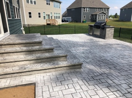 Verona Cobblestone stamped concrete with Pewter integral, Charcoal release, wedding cake cantilever steps and built-in grill with custom top cap in Westfield Indiana – Indy Decorative Concrete