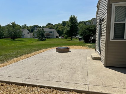 Heavy Stone stamped concrete with Lanon Stone integral, Smoke release, stone liner step and tan block fire pit with leather top cap in Indianapolis Indiana – Indy Decorative Concrete