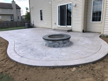 Heavy Stone stamped concrete with Smoke integral, Storm Gray release and gray block fire pit with dark gray top cap in Zionsville Indiana – Indy Decorative Concrete